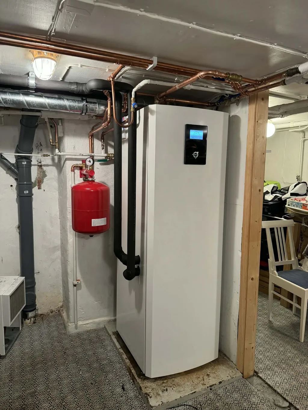 Installerad Thermia bergvärmepump med kopparrör och expansionskärl